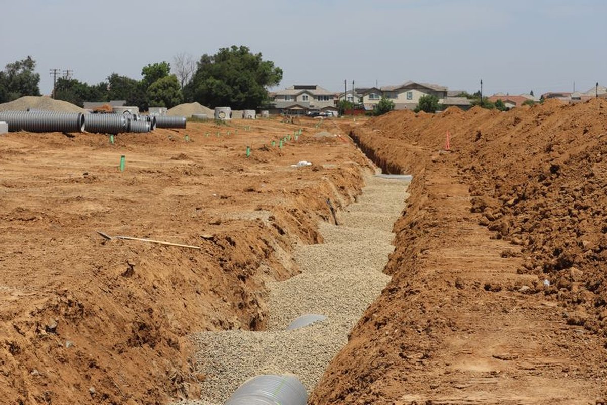 Pohled na staveniště s vykopanými rýhami pro rozvody